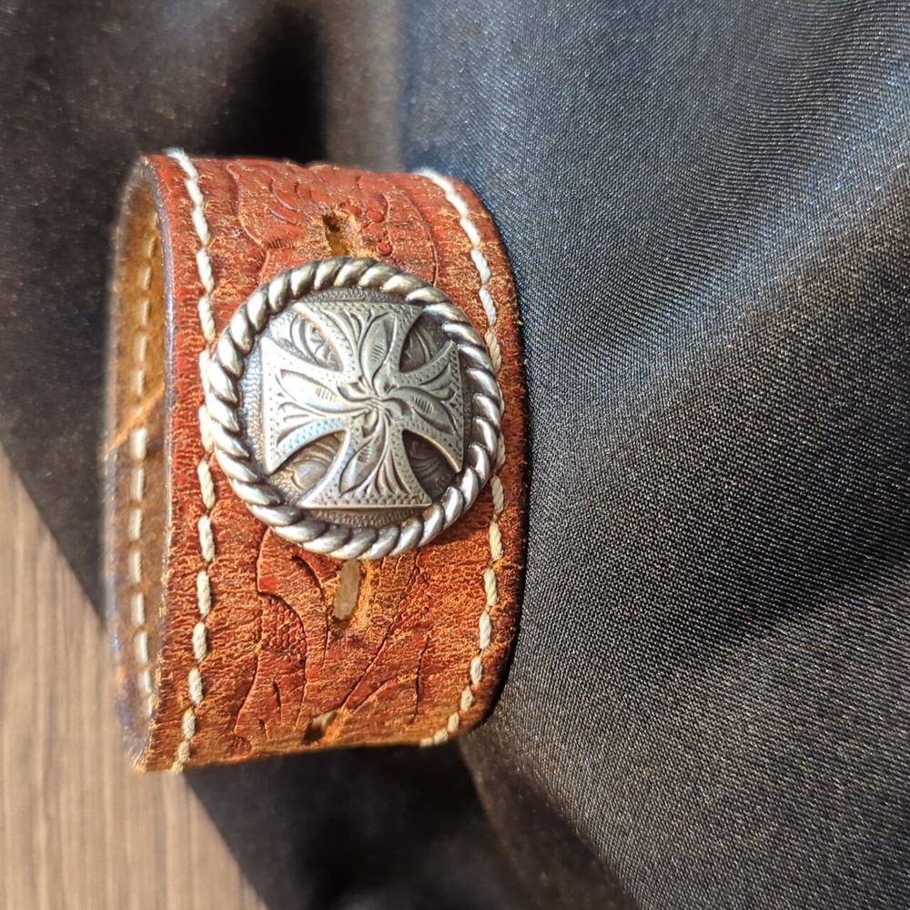 Upcycled leather cuff bracelet with a cross concho. Two snaps